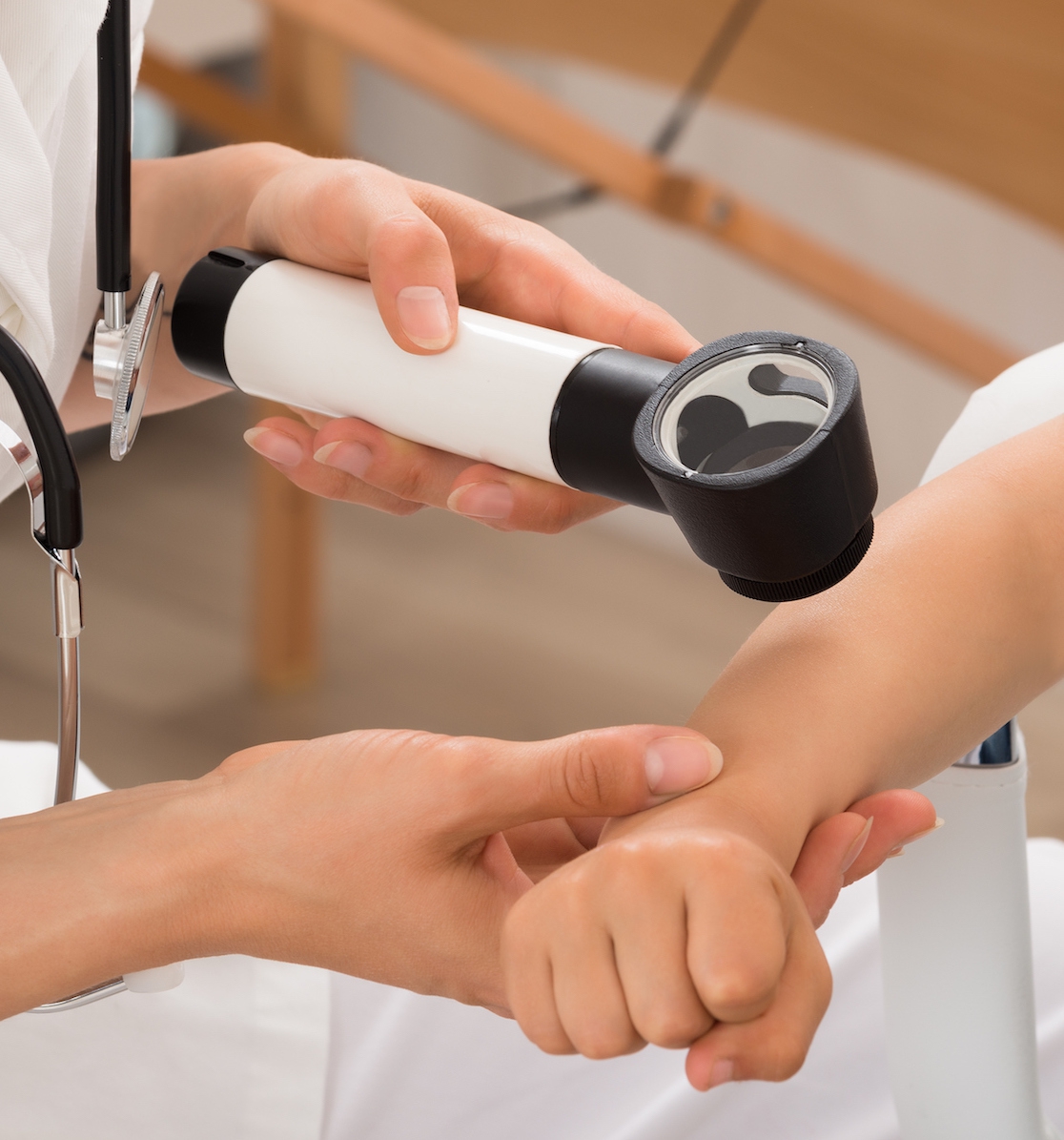 Ärztin untersucht den Arm eines Kindes